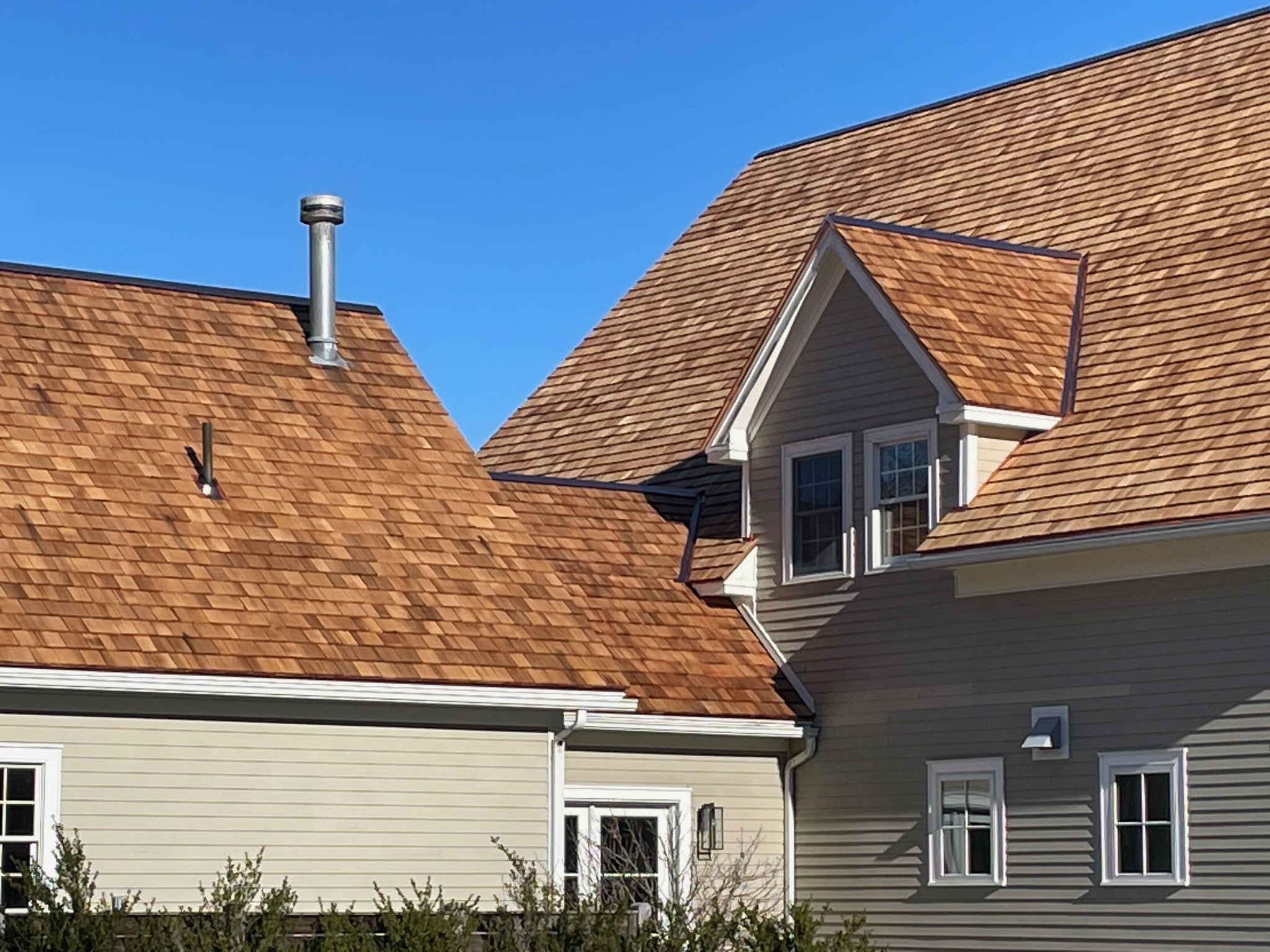 beige house with cedar shingle roofing