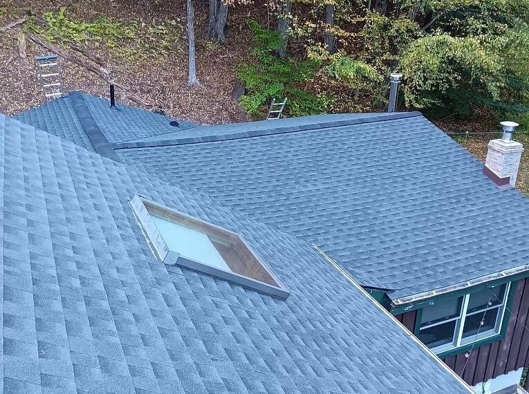 Roof with grey shingles and a skylight